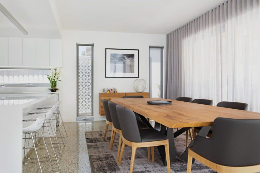 Dining Room With Wooden Table, Gray Chairs, And A Patterned Rug — Winning Blinds in Cardiff, NSW