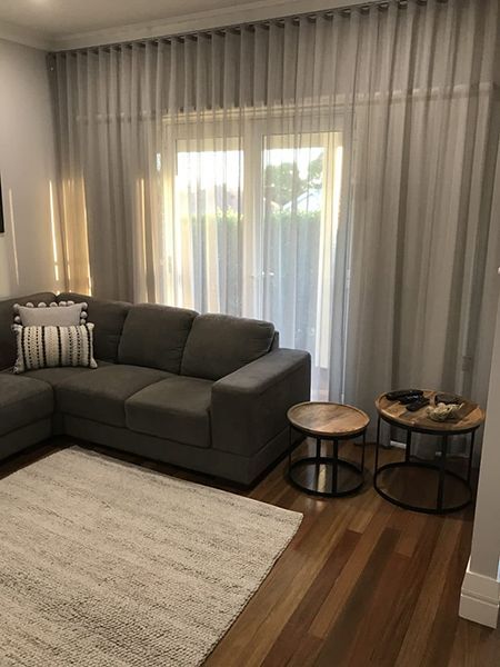 Living Room With Gray Sofa, Rug, And Sheer Curtains — Winning Blinds in Cardiff, NSW