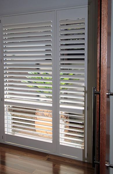White plantation shutters, partially open — Winning Blinds in Cardiff, NSW