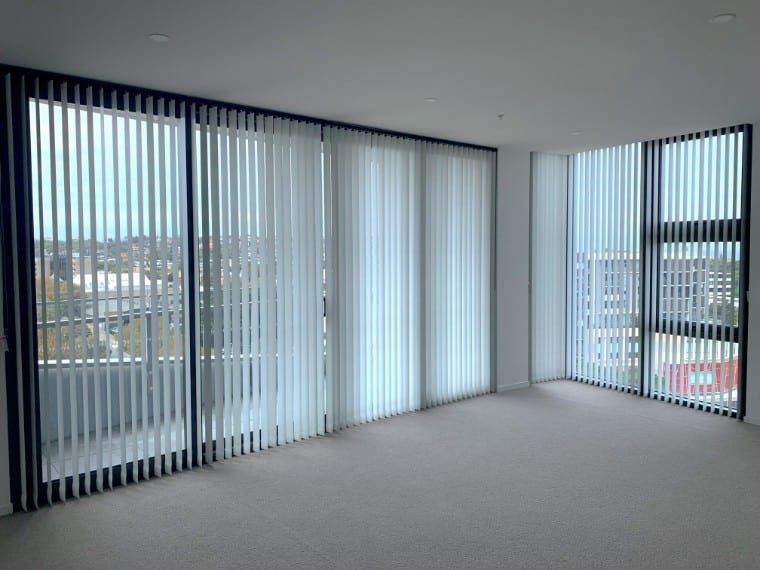 Empty Room With Large Windows Covered By Vertical Blinds — Winning Blinds in Cardiff, NSW