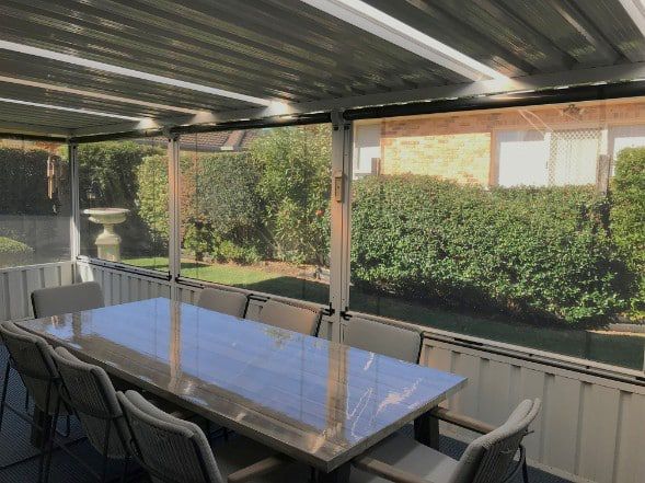 Patio With A Long Table, Chairs, And Screens — Winning Blinds in Cardiff, NSW