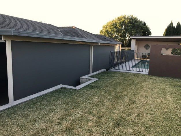 House Exterior With A Pool Area, Surrounded By Grass And Fencing — Winning Blinds in Cardiff, NSW