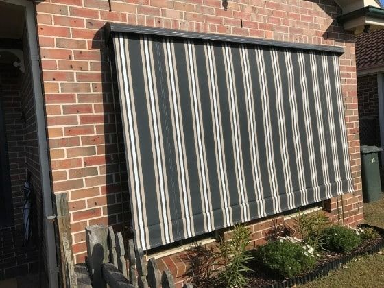 A Balcony with A Black Awning Over a Sliding Glass Door — Winning Blinds in Cardiff, NSW