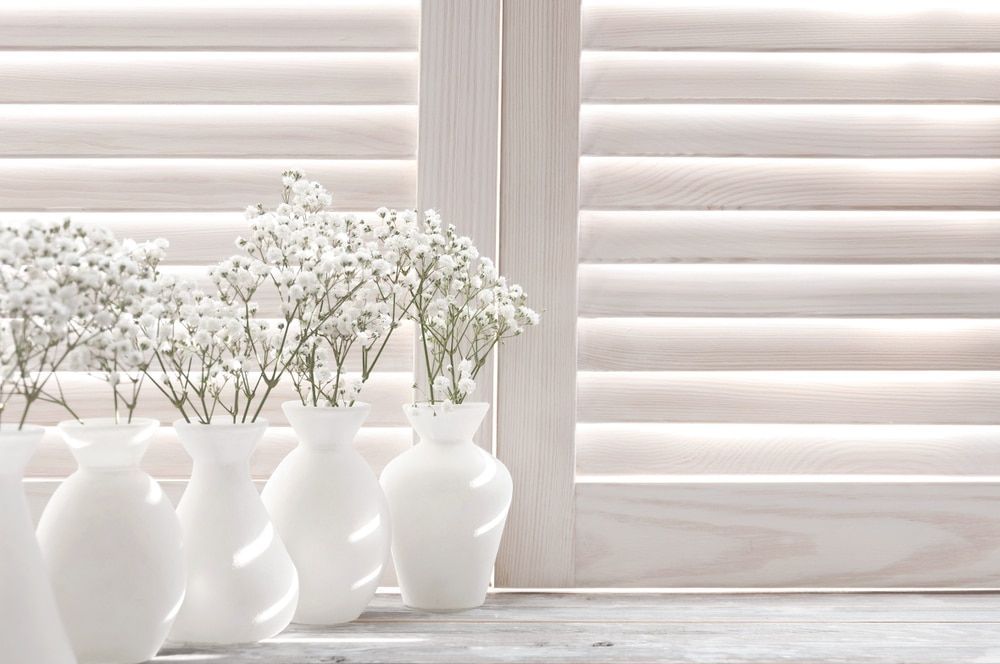 A Room With a Wooden Floor and Shutters on the Wall — Winning Blinds in Cardiff, NSW