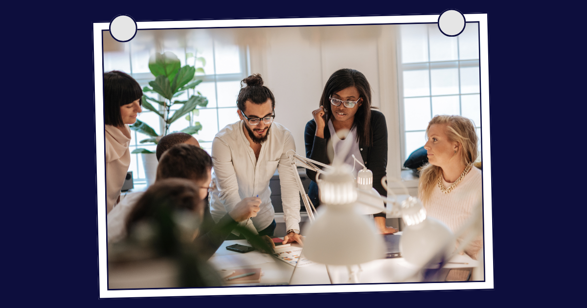 Team collaborating around a table, representing the role of EVP in recruitment marketing strategy.