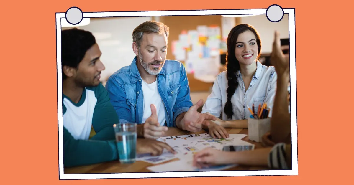 A group of people are sitting around a table having a meeting.