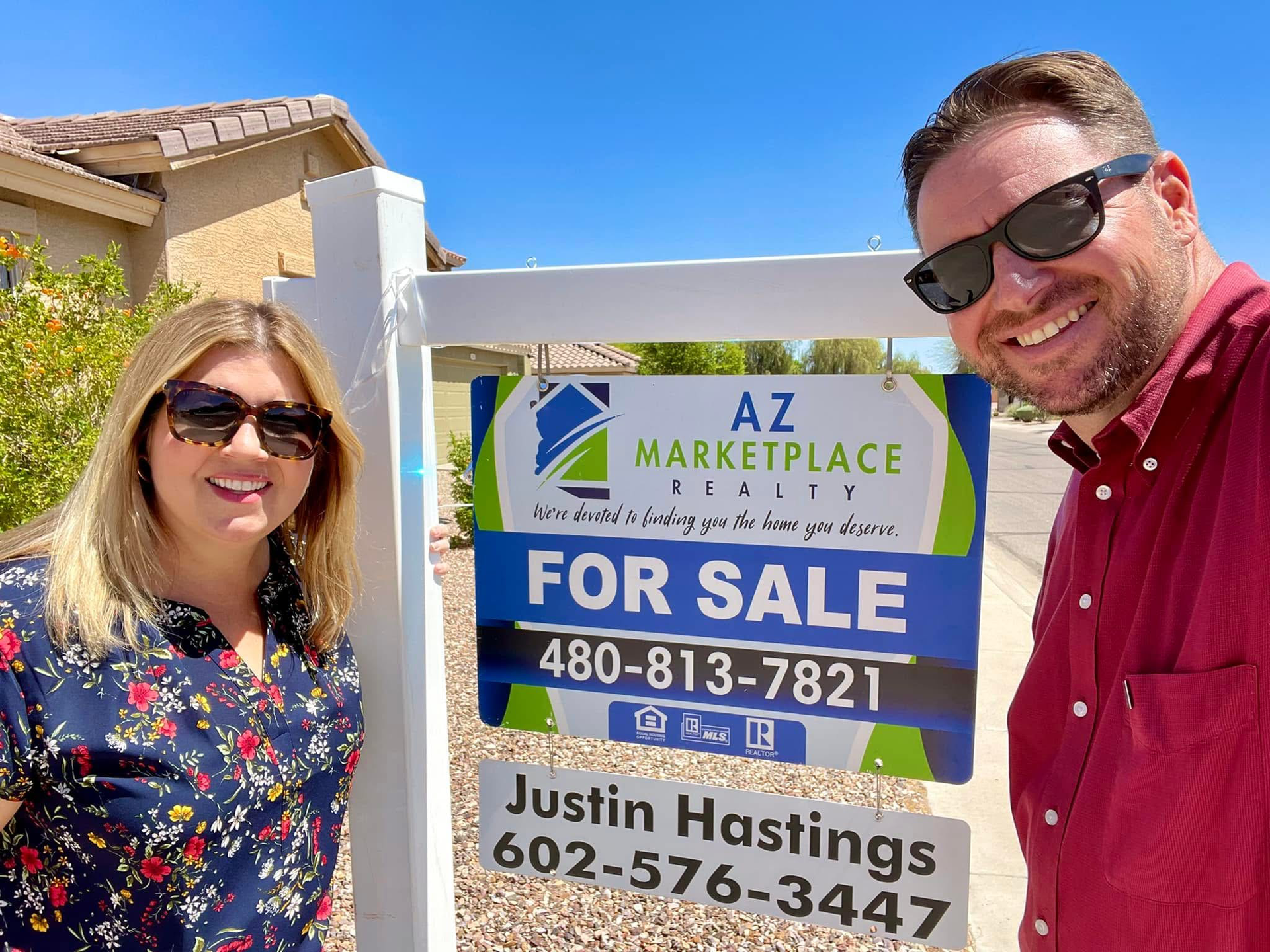 A woman is holding a sold sign in her hands