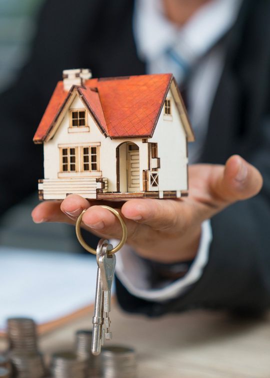 Man holding model house with keys