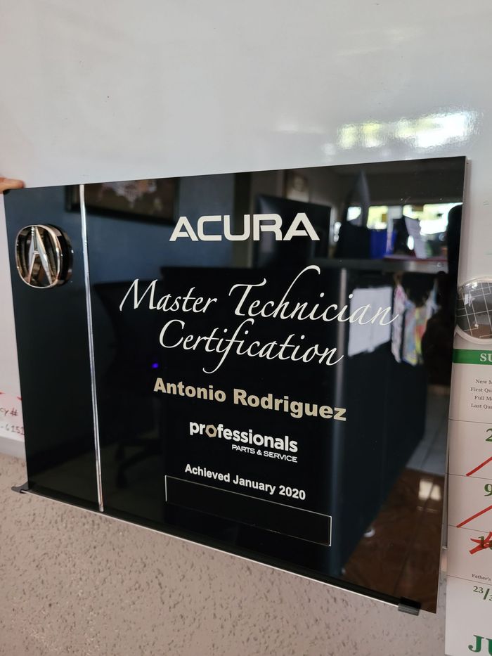 A black plaque that says acura master technician certification