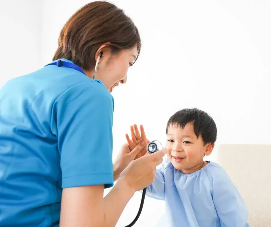 Pediatric nurse checking a toddler’s heartbeat