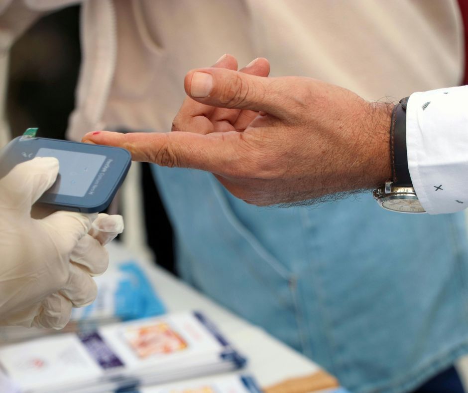 Finger-prick blood sugar test using a glucometer.