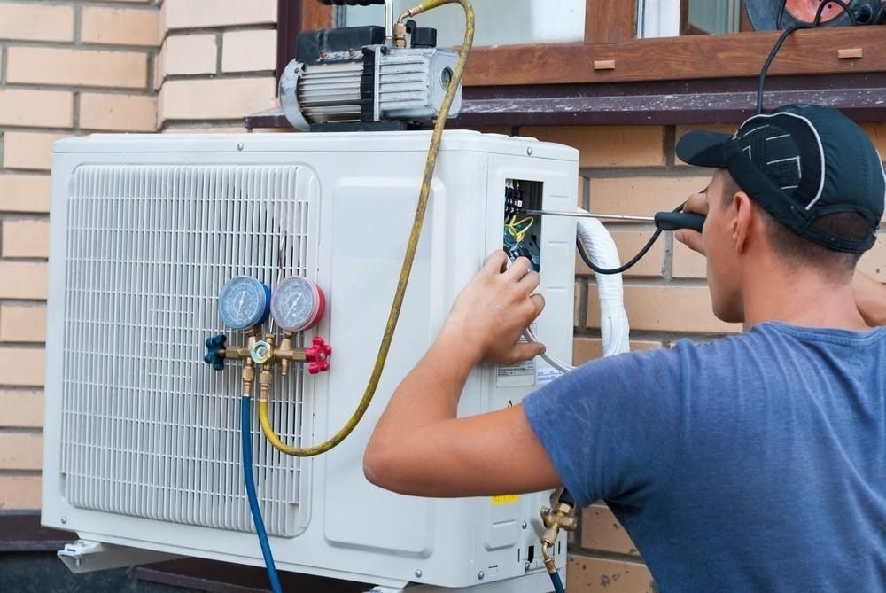 a man is working on an air conditioner outside of a building .