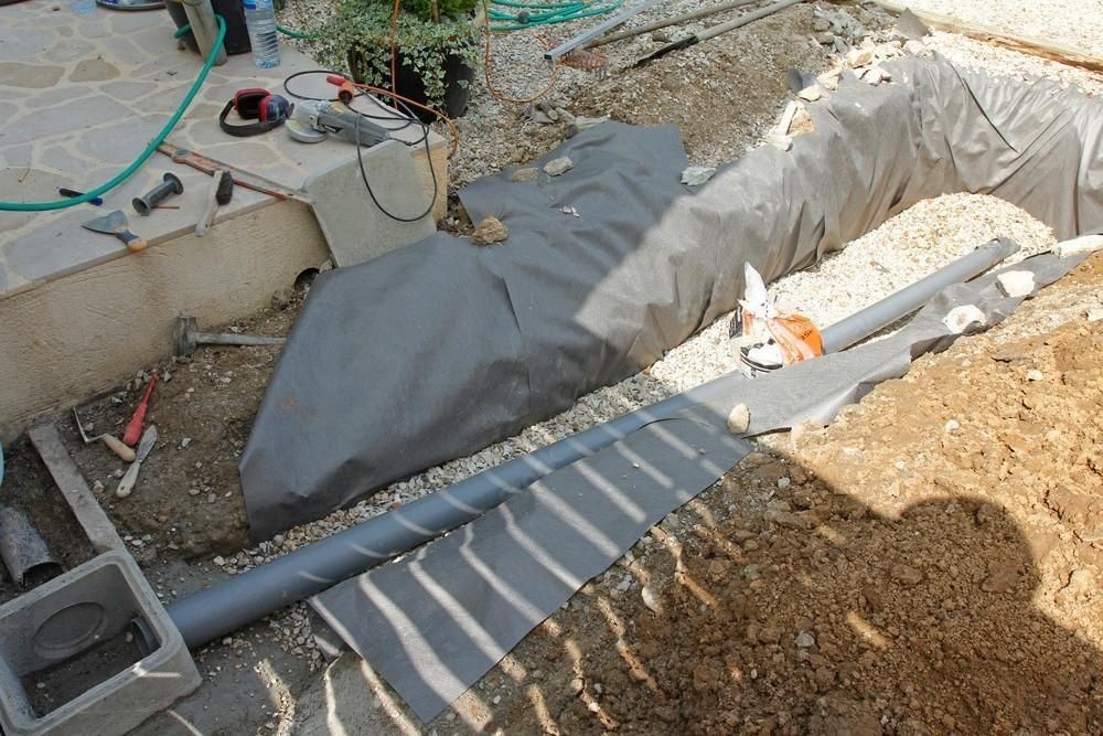 a hose is laying in the dirt next to a pipe .