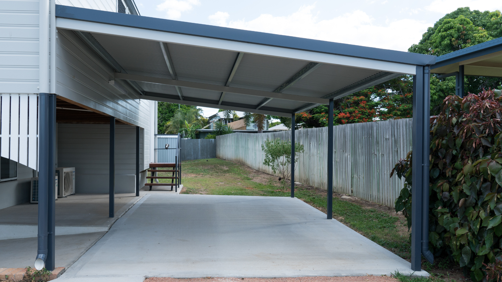 There is a carport in the backyard of a house.