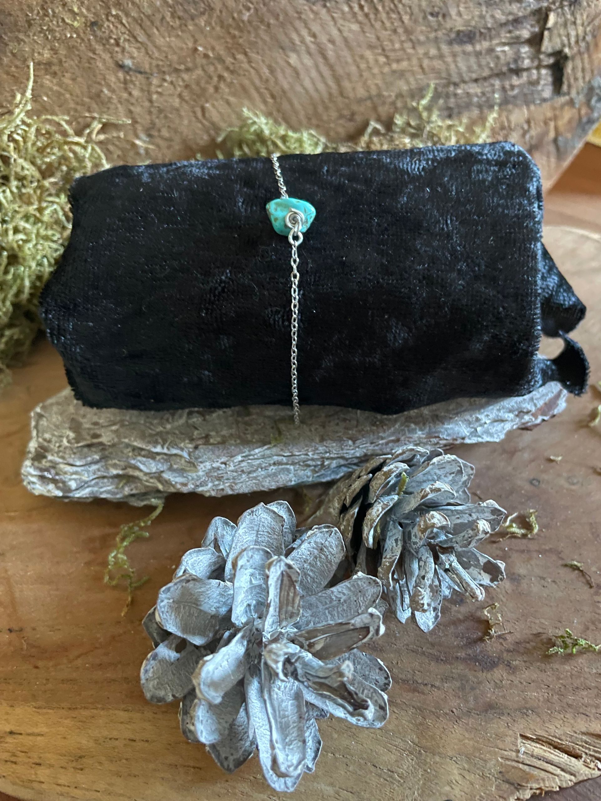 Zilveren schakelarmband met een turkooizen steen.