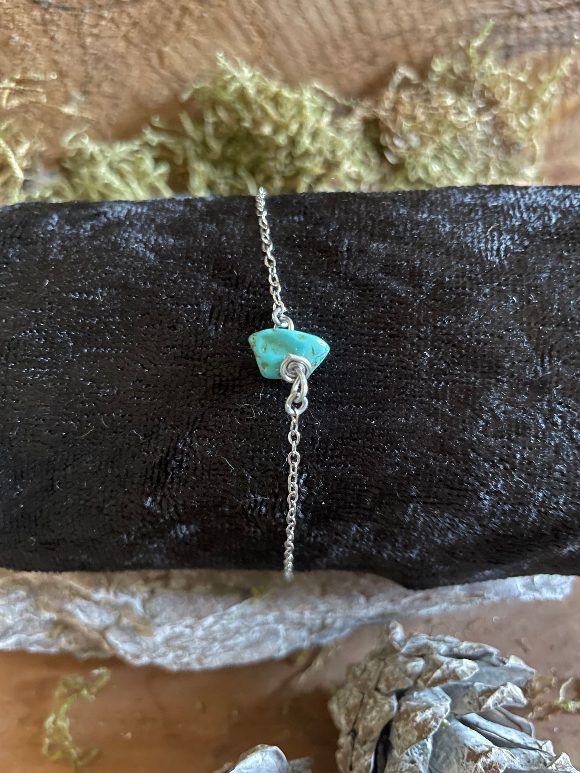 Zilveren schakelarmband met een turkooizen steen.