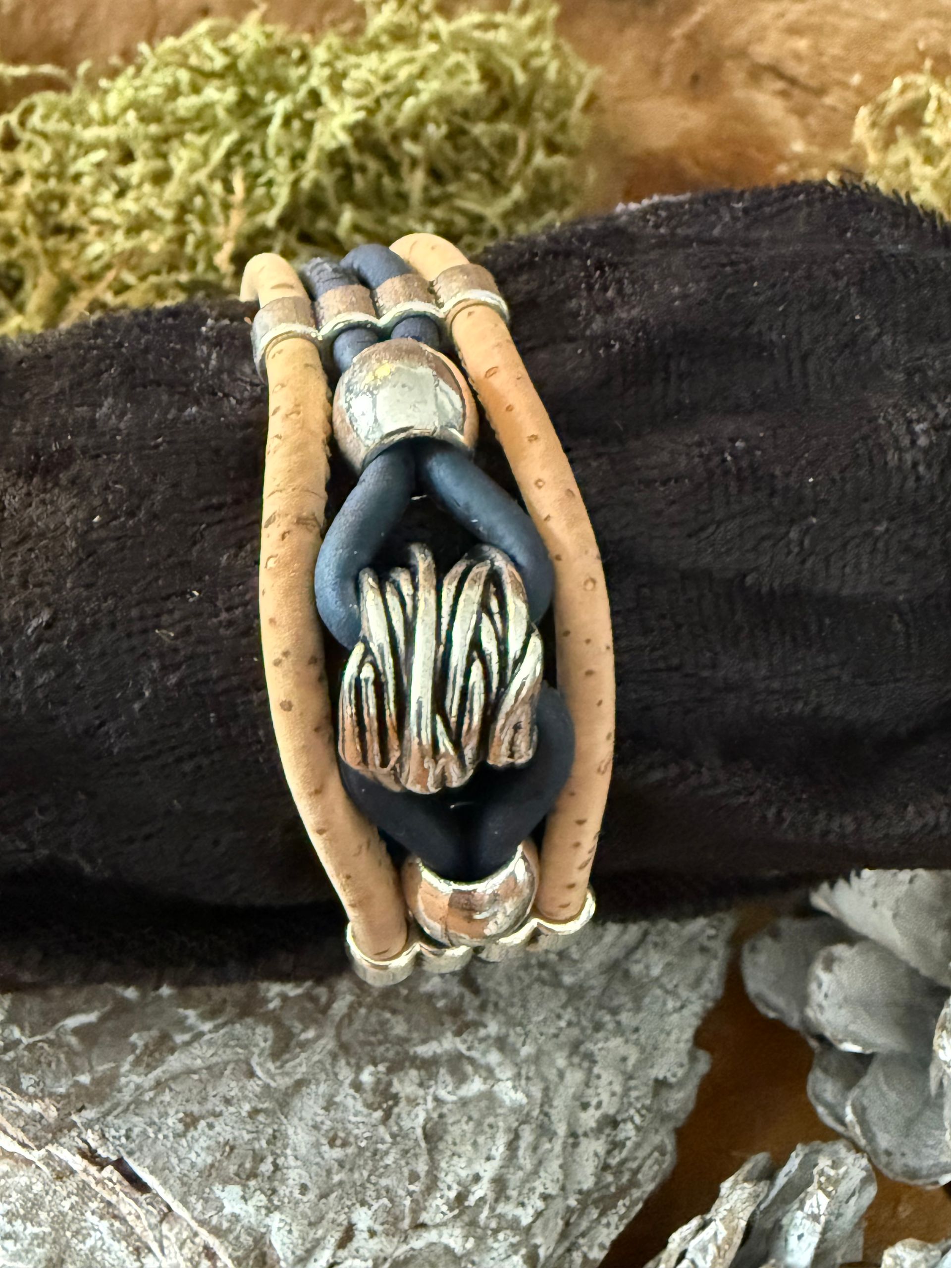 Armband met kurken en zwarte leren bandjes, zilveren accenten.