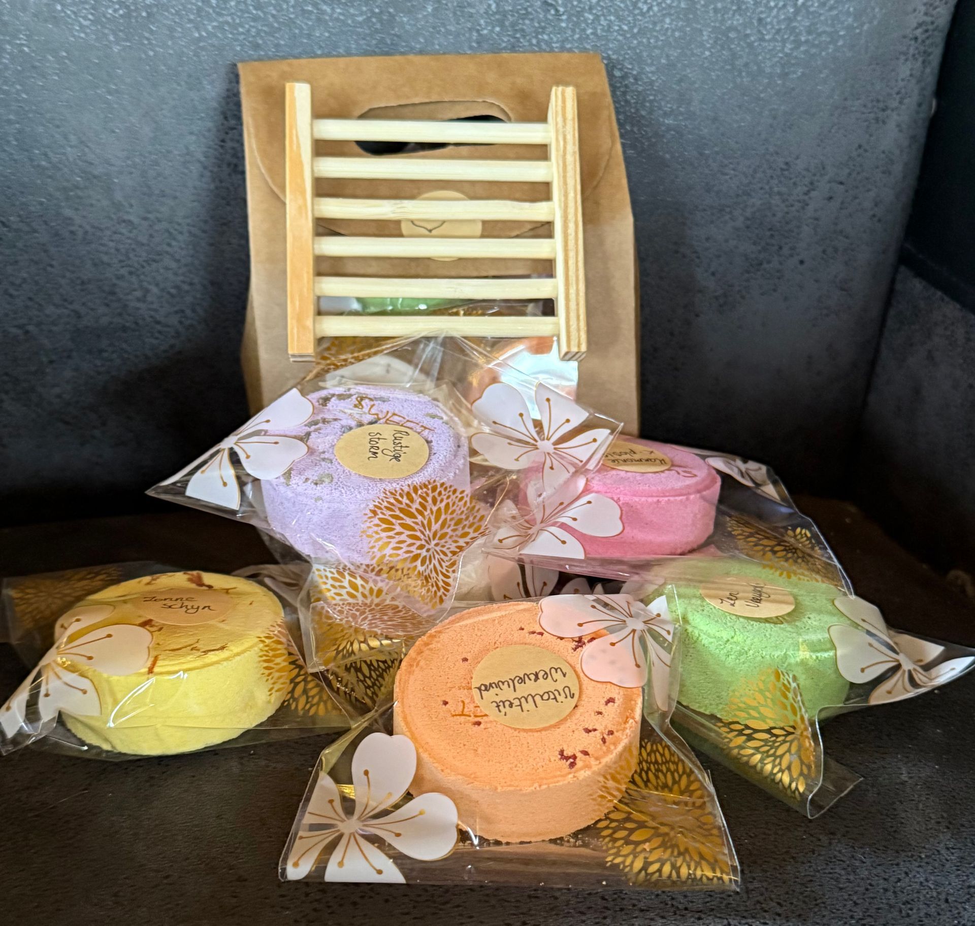 Cadeauset met badbommen in verschillende kleuren en een houten zeephouder in een bosachtig thema.