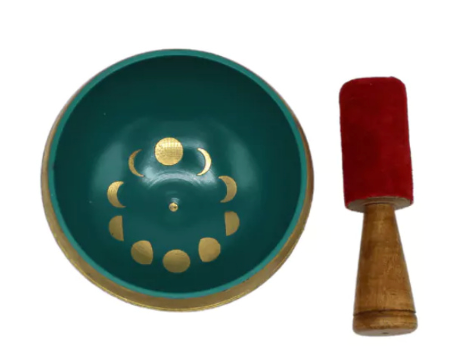 Witte klankschaal met gouden maanfasen, rode vilten hamer.