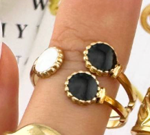 Gouden ring met twee zwarte en één witte ovale versiering.