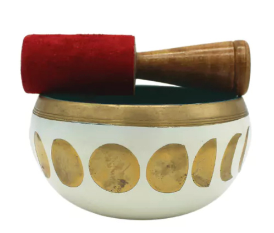 Witte klankschaal met gouden maanfasen, rode vilten hamer.