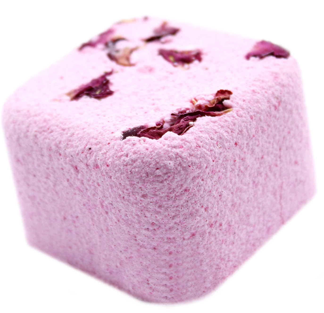 Roze, kubusvormige bruisbal voor in bad met gedroogde rozenblaadjes op een groene, gestructureerde achtergrond.