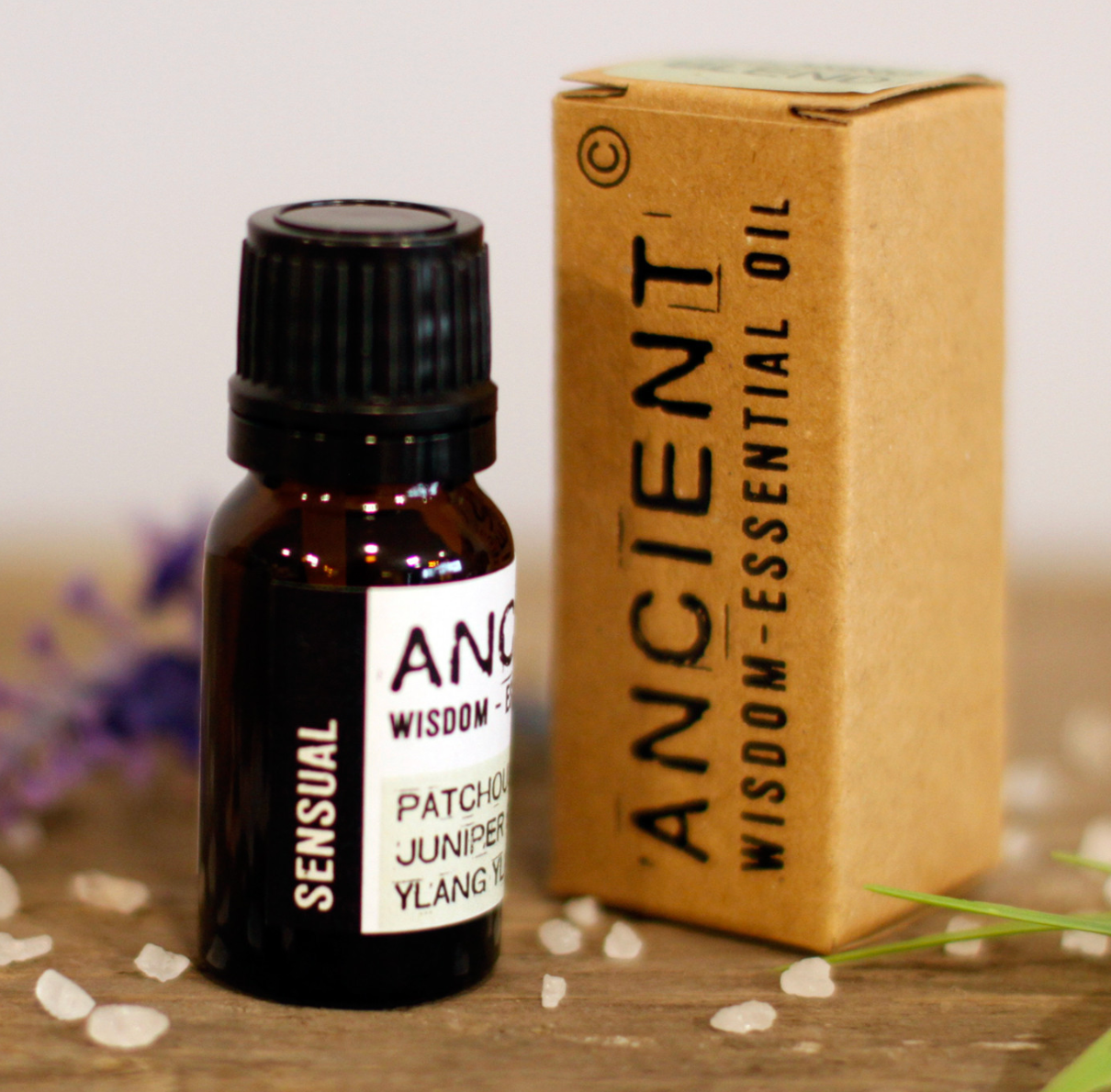 Flesje 'Sensual' etherische olie met doosje op een houten ondergrond.