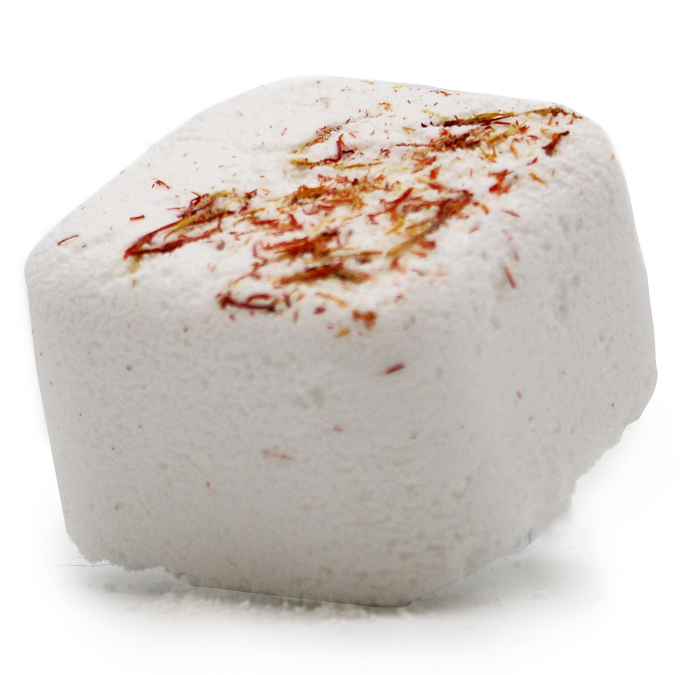 Een bruisbal in bad op een steen, met lavendel, limoen, een kaars en kruiden op de achtergrond.