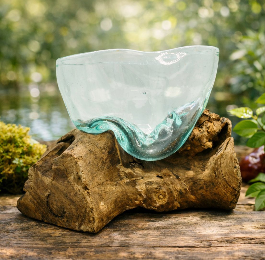 Doorzichtige glazen schaal met golvende rand, rustend op een bruine houten voet, geschikt voor buitengebruik.