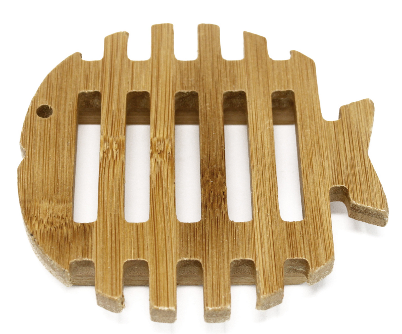 Een houten onderzetter in de vorm van een vis op een boomstronk in een bosrijke omgeving.