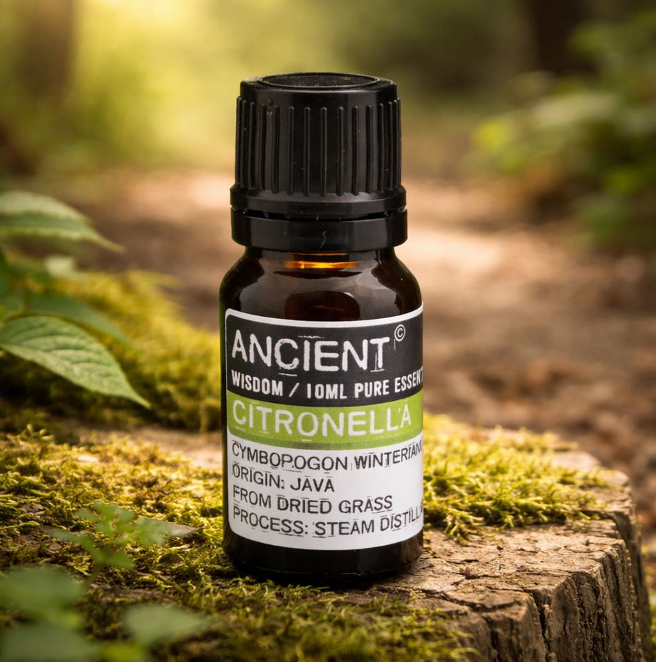 Een flesje citronella-etherische olie op een met mos bedekte ondergrond in een buitenomgeving.