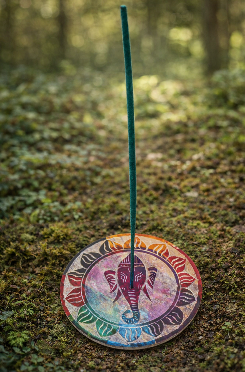 Een ronde onderzetter met een afbeelding van Ganesha in een kleurrijke, bloemachtige mandala op een met bedekte ondergrond.