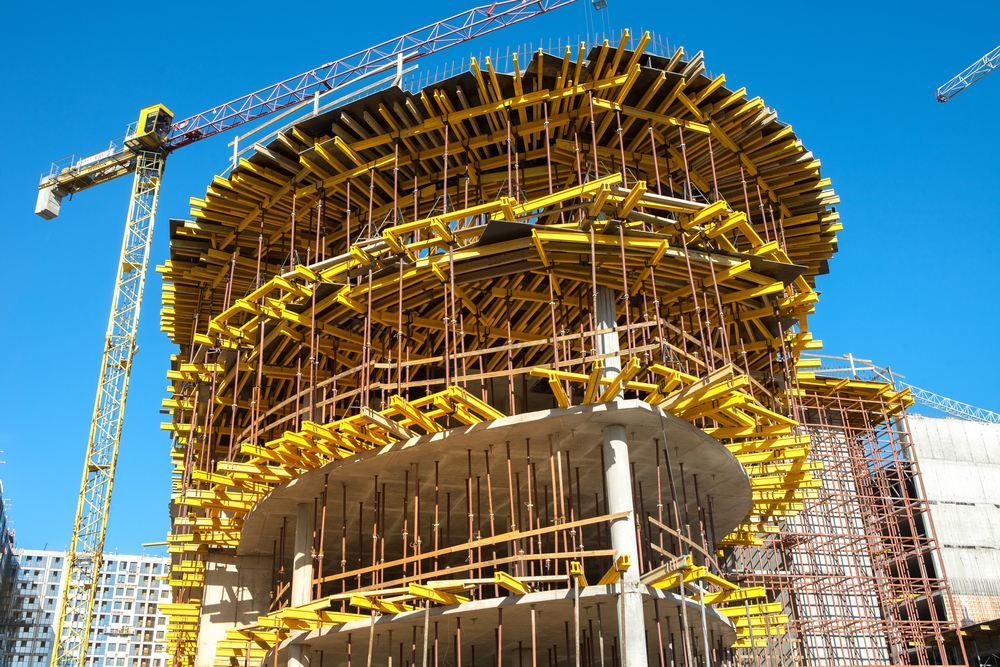 A Large Building Is Being Built With A Crane In The Background — Fahlstrom Scaffolding Cairns Pty Ltd in Gordonvale, QLD