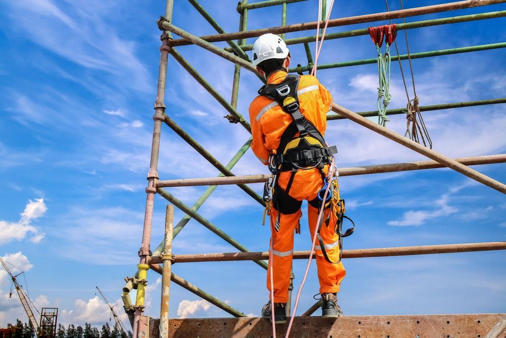 A Construction Worker Is Standing On Top Of A Scaffolding  — Fahlstrom Scaffolding Cairns Pty Ltd in Tablelands, QLD