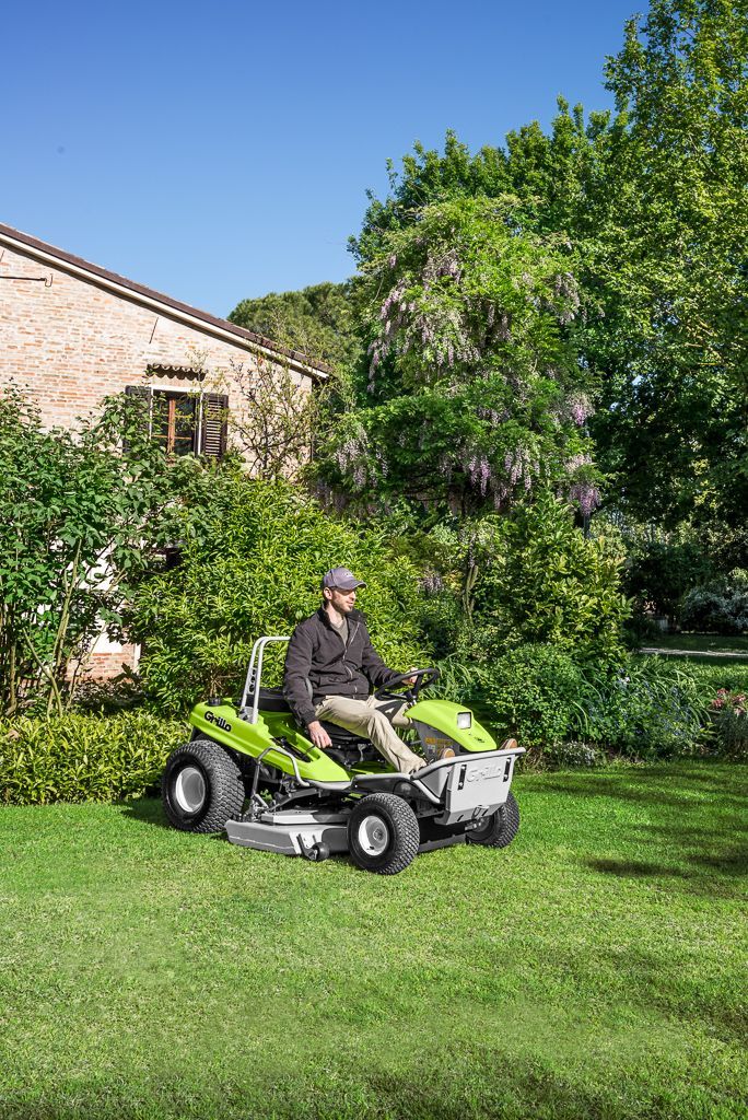 A Man Wearing a Blue Hat is Riding a Lawn Mower — Stockers & Partridge In Pokolbin, NSW