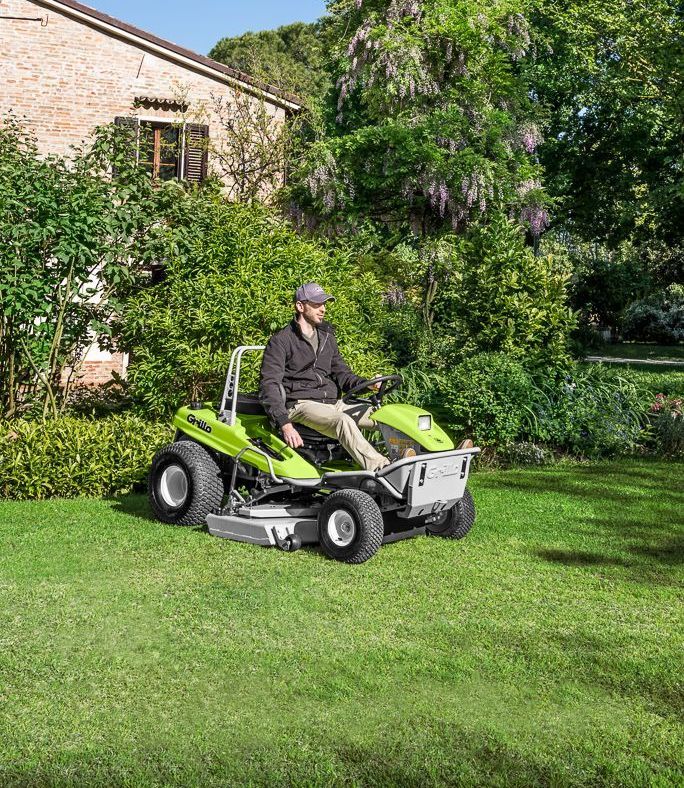 A Green Lawn Mower is Mowing a Lush Green Field — Stockers & Partridge In Raymond Terrace, NSW
