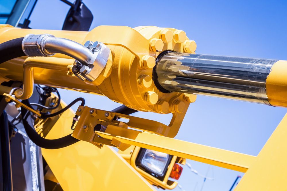 A Close Up of a Yellow Hydraulic Cylinder on a Bulldozer — Stockers & Partridge In Dungog, NSW