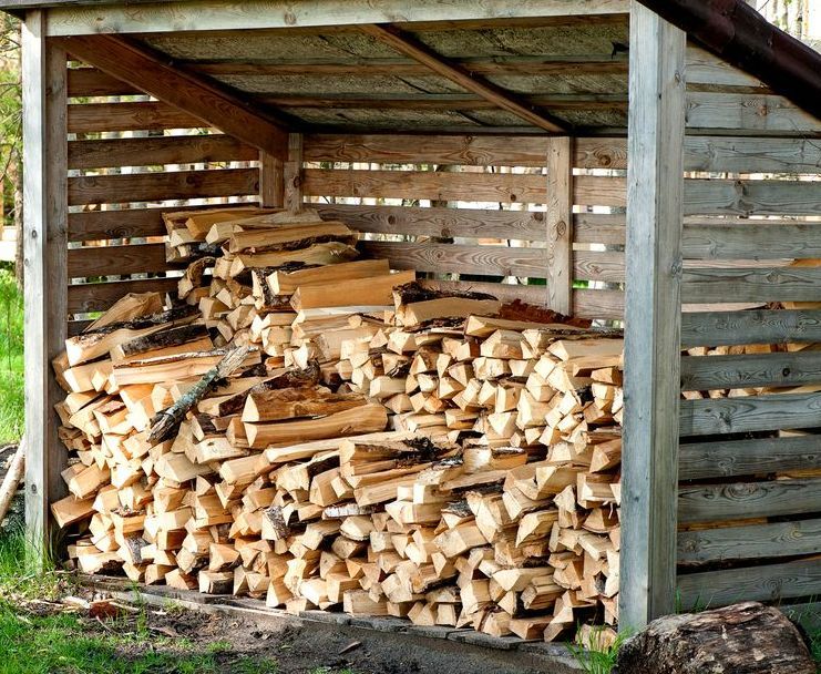 A Wooden Shed With a Pile of Logs Inside of It — Stockers & Partridge In Raymond Terrace, NSW
