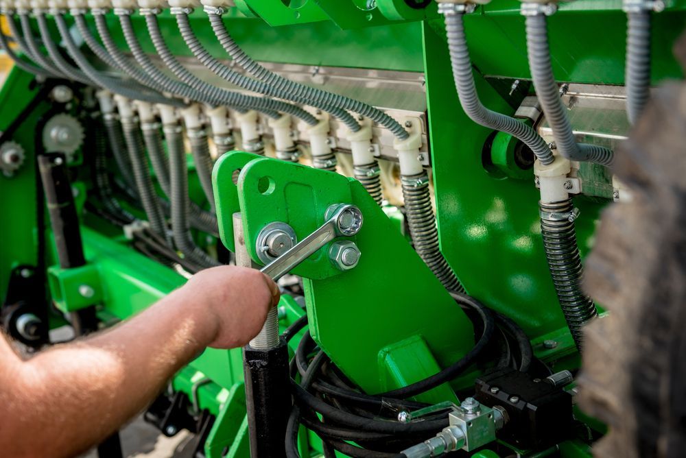 A Person is Working on a Green Tractor With a Wrench — Stockers & Partridge In Raymond Terrace, NSW