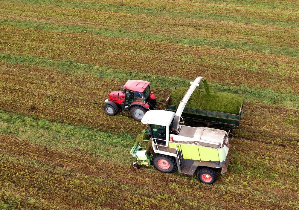 An Aerial View of a Tractor and a Combine Harvester in a Field — Stockers & Partridge In Raymond Terrace, NSW