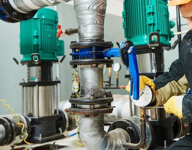 A Man is Working on a Water Pump in a Factory — Stockers & Partridge In Raymond Terrace, NSW