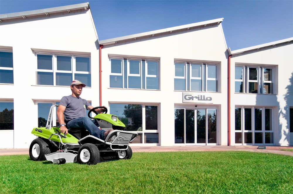 A Man is Riding a Lawn Mower in Front of a Building — Stockers & Partridge In Paterson, NSW