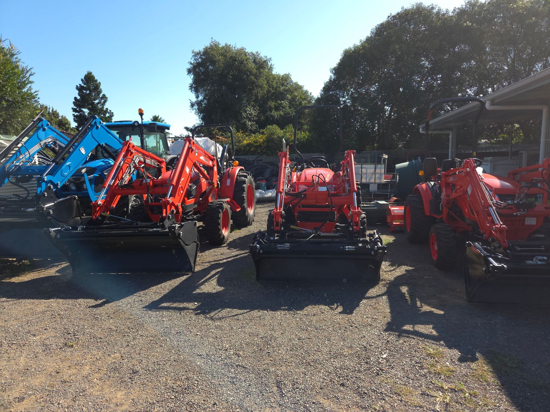 A Row of Tractors Are Parked in a Gravel Lot — Stockers & Partridge In Paterson, NSW