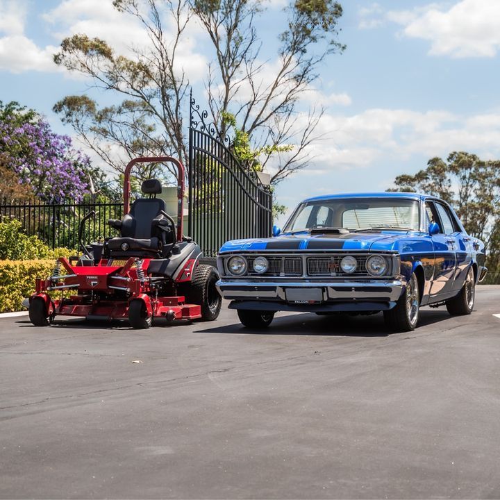 A Red Lawn Mower is Parked Next to a Blue Car — Stockers & Partridge In Paterson, NSW