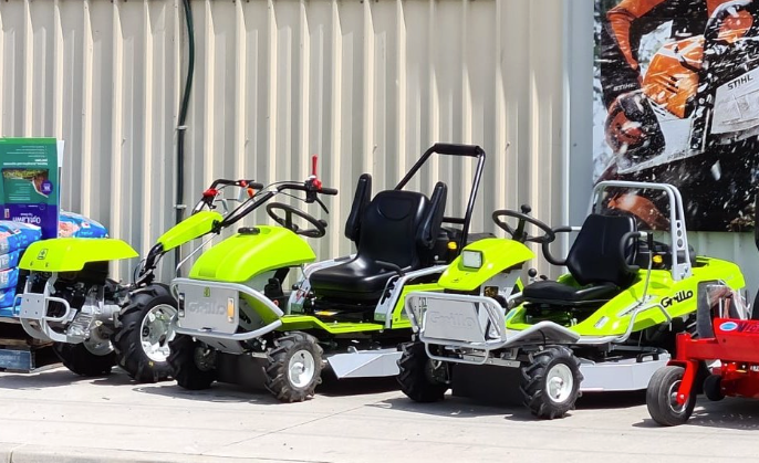 A Man is Riding a Lawn Mower in Front of a Fence — Stockers & Partridge In Paterson, NSW