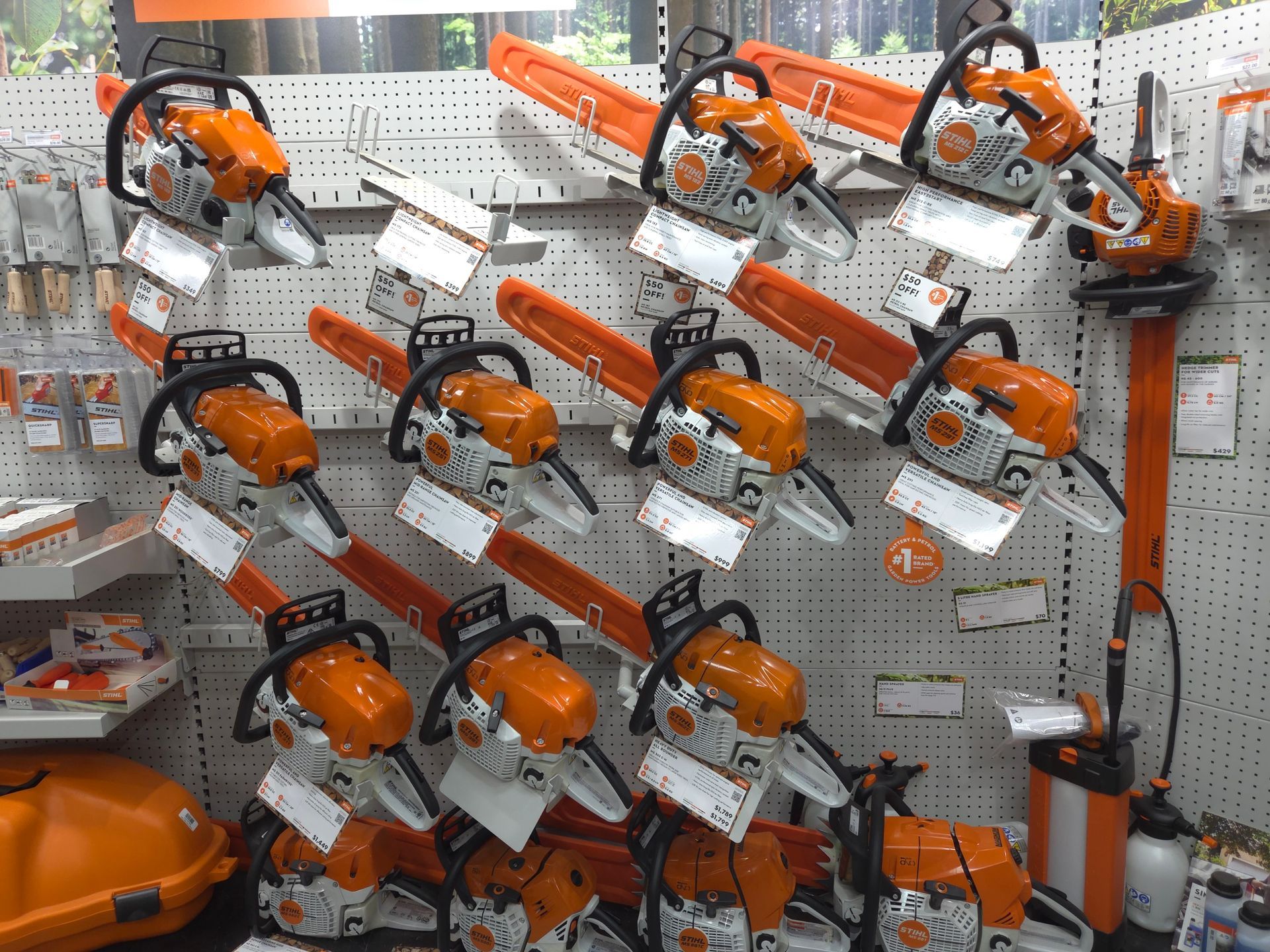 A Bunch of Chainsaws Are Hanging on a Wall in a Store — Stockers & Partridge In Paterson, NSW