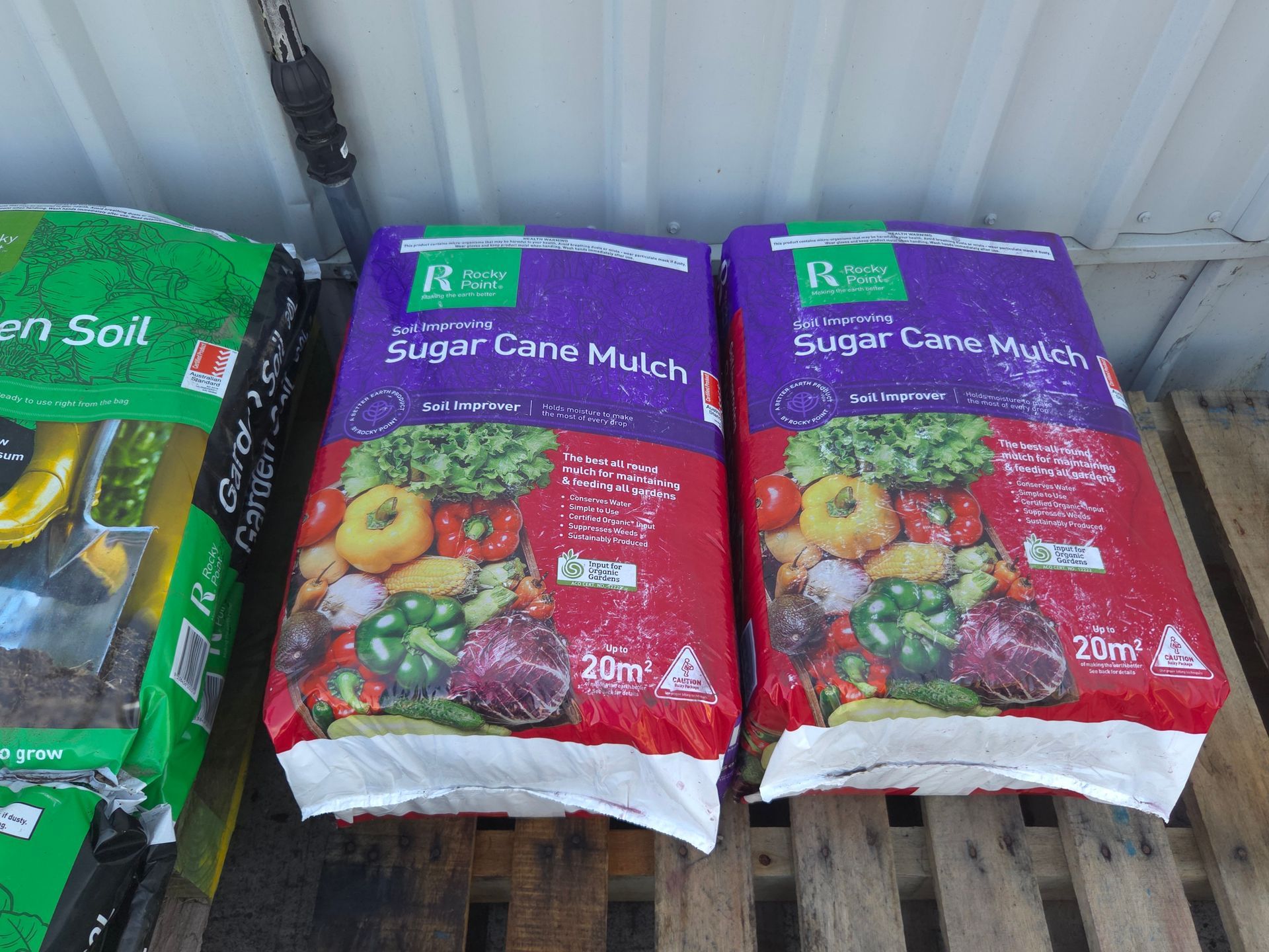Two Bags of Sugar Cane Mulch Are Sitting on a Wooden Shelf — Stockers & Partridge In Paterson, NSW