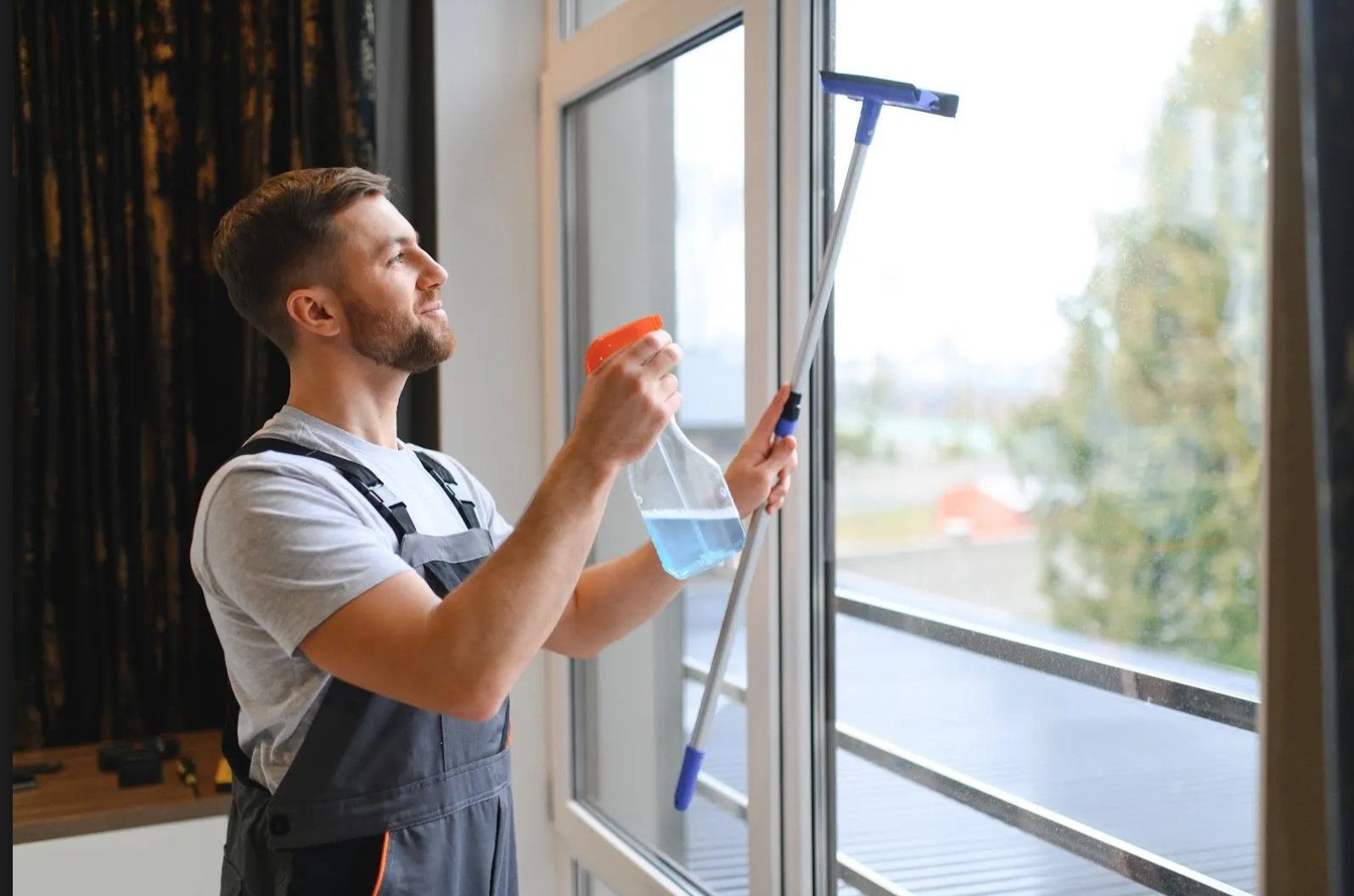 A man is cleaning a window with a squeegee.
