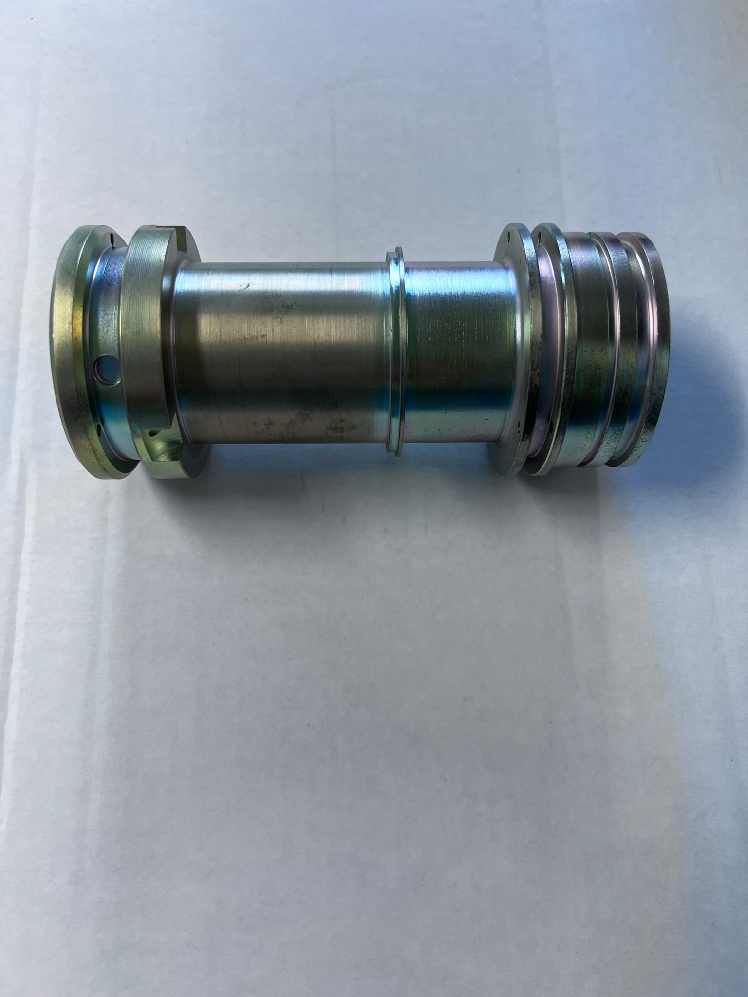 A metal pipe is sitting on top of a white surface.