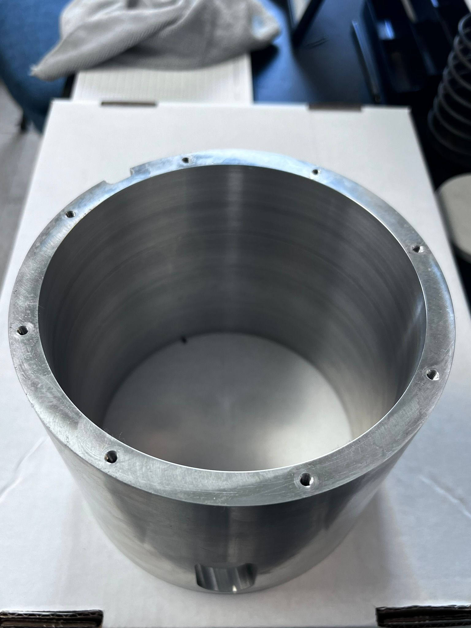 A metal cylinder is sitting on top of a white box